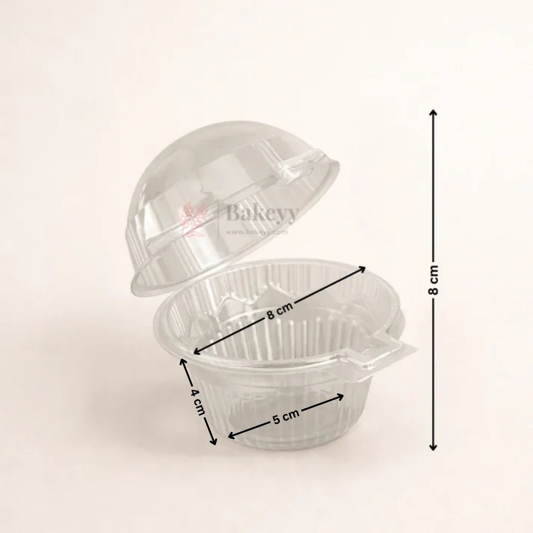 A clear plastic bakery cupcake container with its lid partially open, overlaid with black dimension arrows and labels showing 8 cm height, 8 cm diameter, 4 cm depth, and 5 cm base diameter on a light beige background.