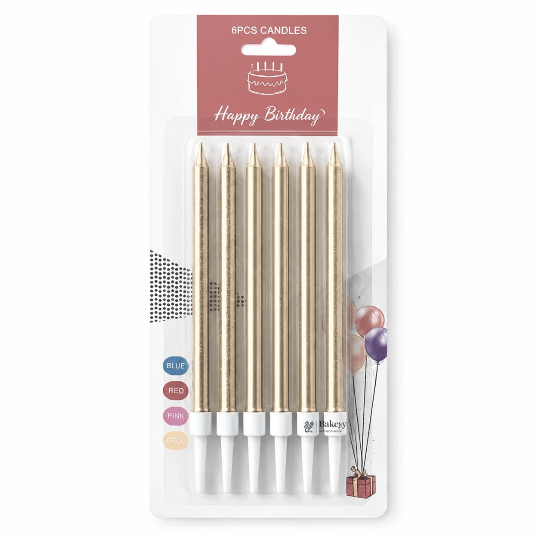 Six gold birthday candle sticks in a blister pack with a pink 'Happy Birthday' header card. The candles have white tips and are shown on a clean white background.