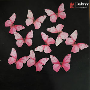 Nine pink and white butterfly-shaped baked goods arranged on a black background, with a Bakeey logo in the top right corner.