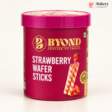 A tub of BYOND Strawberry Wafer Sticks on a clean white background. The packaging is a deep magenta pink with gold and white branding, and an illustration of two striped wafer sticks with a strawberry on top.