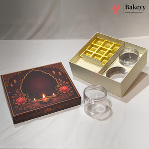 A gift box set for sweets or chocolates, featuring a dark brown decorative lid with floral and diya (oil lamp) illustrations, an open cream-colored box with a gold tray and two clear plastic jars, and two empty clear plastic jars on a white draped fabric background.