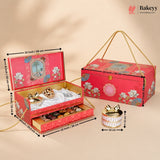 Red floral gift box set with dimension annotations, including an open box showing confectionery contents, a closed box with rope handles, and a small cylindrical tin. The Bakeyy logo appears in the top right.