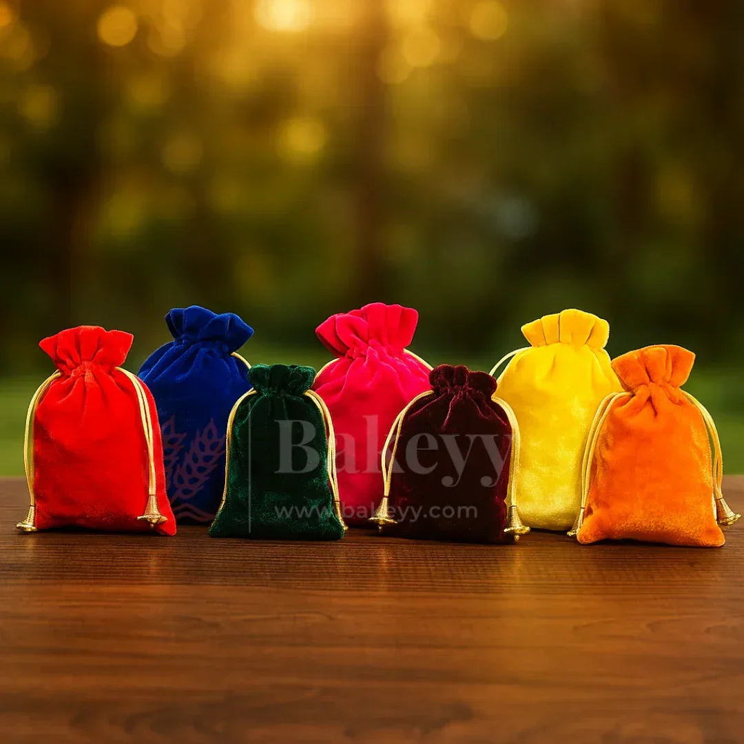 Colorful velvet potli gift bags on wooden table, perfect for hamper making at Bakeyy.com