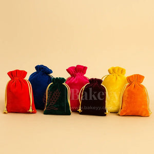 Colorful velvet gift potli bags with gold drawstrings for bakery packaging by Bakeyy.com