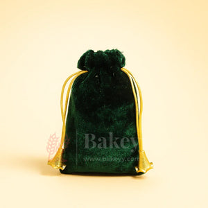 Green velvet potli gift bag with golden drawstring on light background, Bakeyy packaging