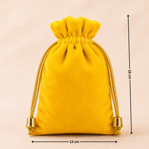Yellow velvet drawstring pouch with measurements on a beige background