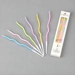 Wavy spiral birthday cake candles in pastel colors with holders, Bakeyy.com packaging.