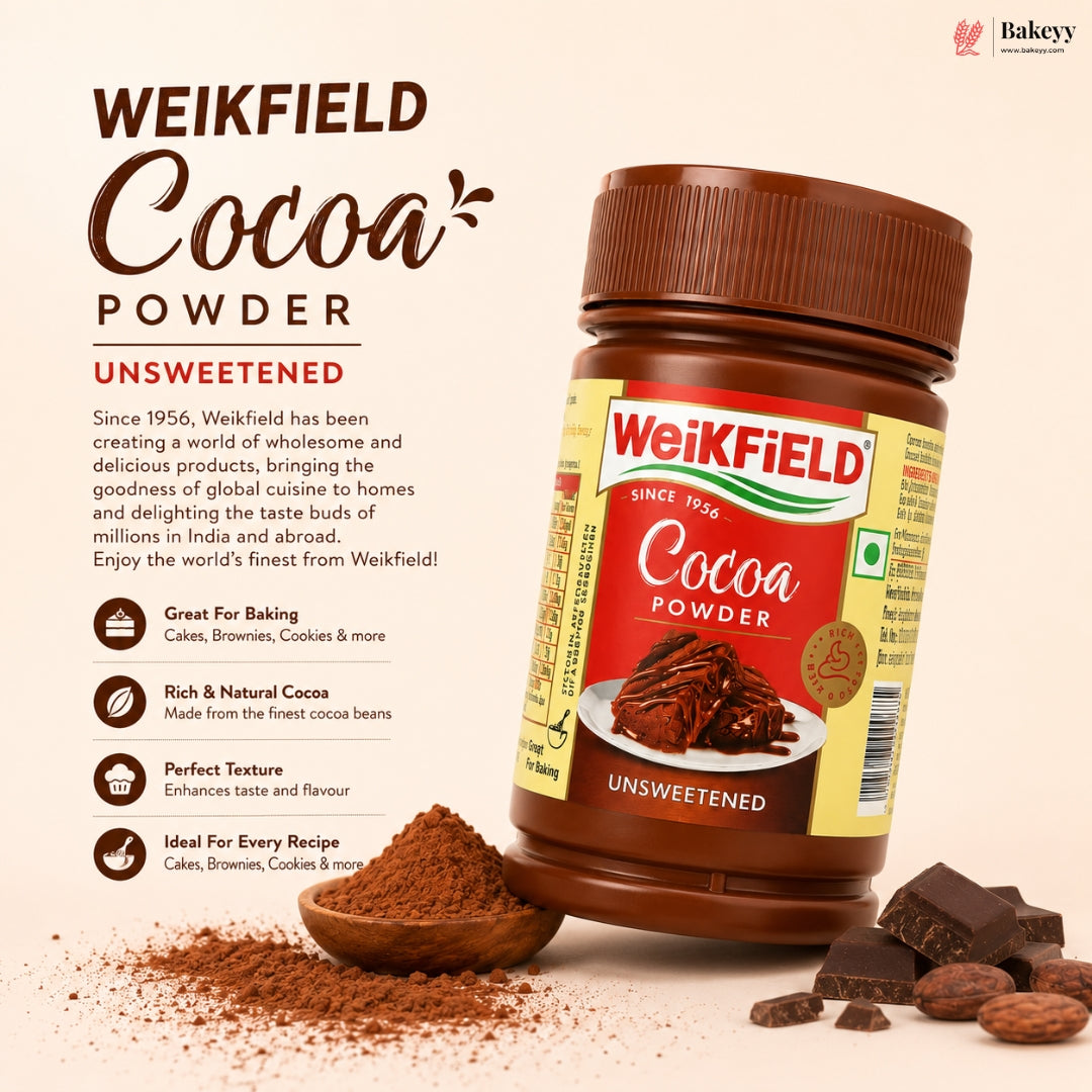 A bottle of Weikfield Unsweetened Cocoa Powder shown on a warm beige background with decorative cocoa powder, chocolate pieces, and text describing the product. The Weikfield brand logo is clearly visible on the bottle and in the top right corner.