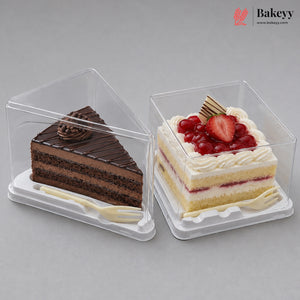 Two clear plastic cake boxes on a gray background, one containing a chocolate cake slice and the other a layered sponge cake with strawberries and cream. A Bakeyy logo is visible in the top right corner.