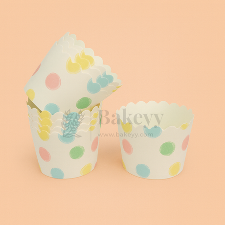 Two cupcake liners with polka dot and plant design on a peach background, branded 'Bakevv'.