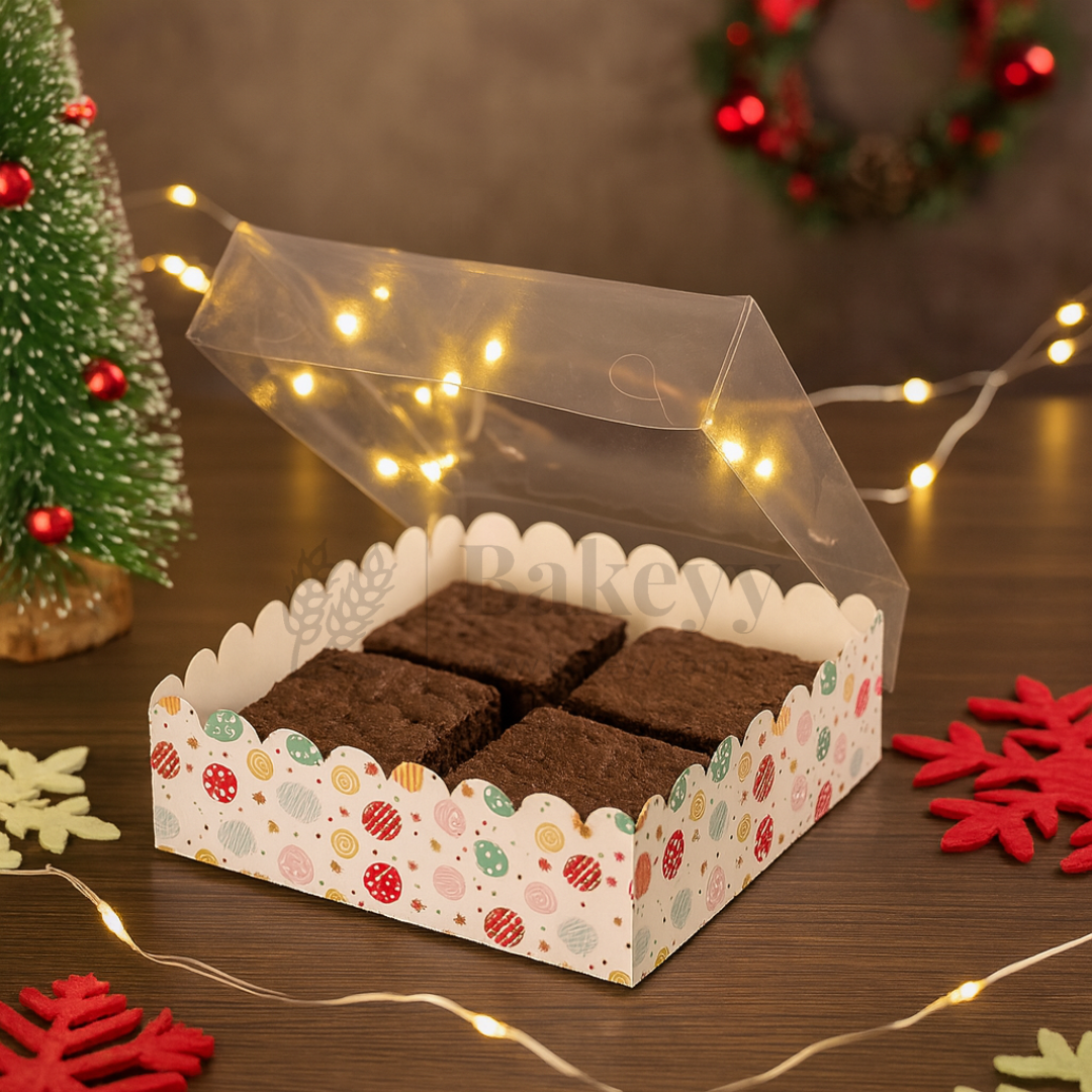 Box of brownies with a decorative lid on a festive background with Christmas decorations.