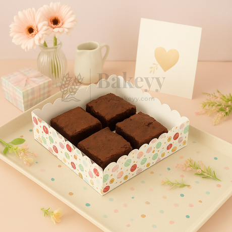 Box of brownies with decorative packaging on a pastel background