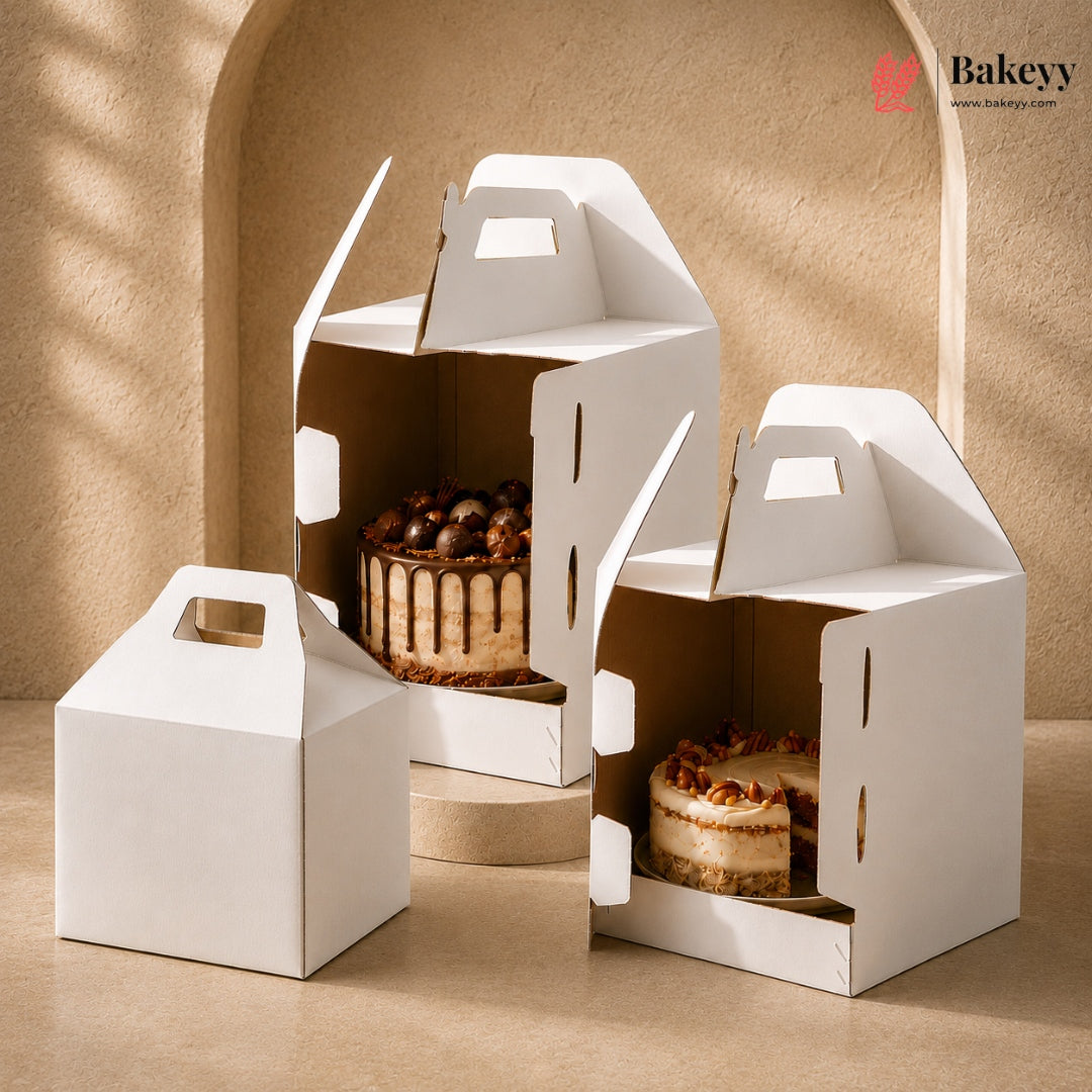 Set of white cake boxes with baked cakes inside on a beige background, featuring the Bakeyy brand.