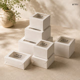 Stack of white boxes with 'Your Logo' text on a beige surface with a plant in the background