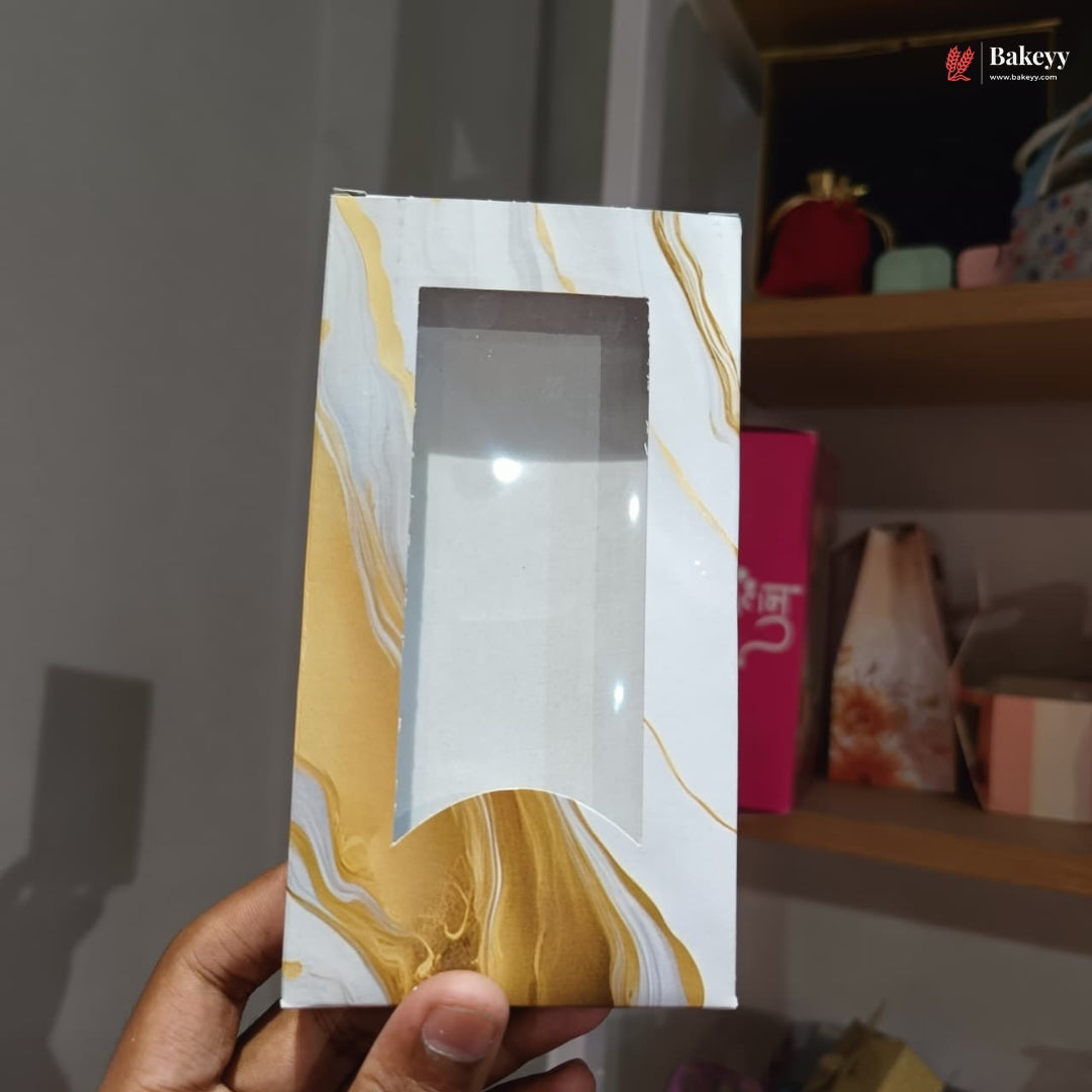 Marble-patterned box with a window held by a hand against a blurred background