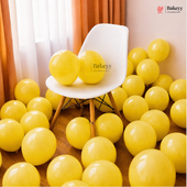 Yellow party balloons filling a room with a white molded chair in the center, sheer curtains, and a warm peach wall. A Bakeey logo watermark is visible on the chair and in the top right corner.