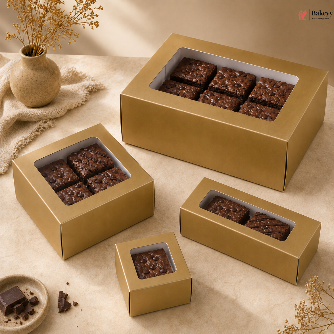 Gold gift boxes containing brownies on a beige surface with decorative elements.