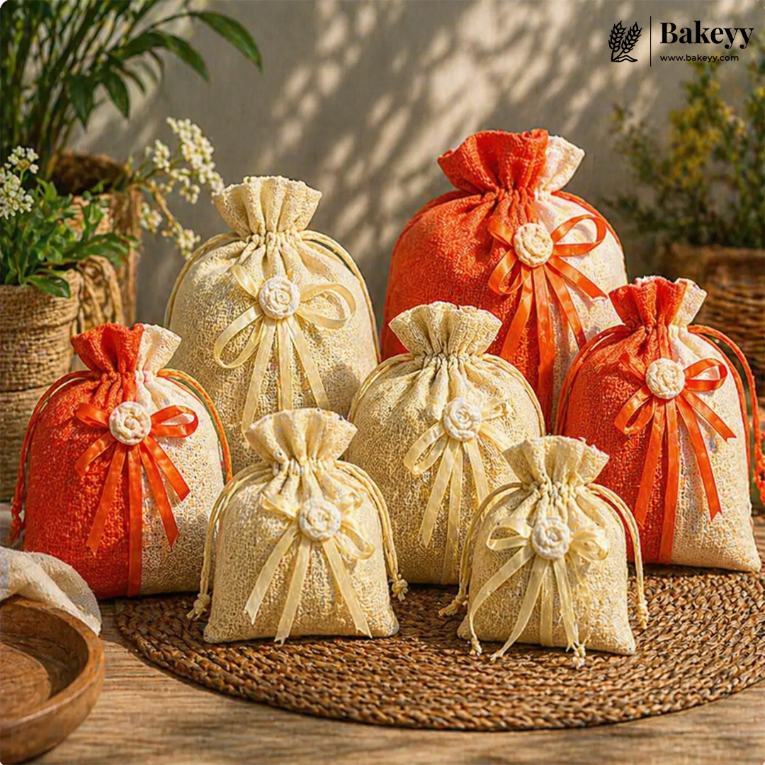 Decorative gift bags in orange and beige on a woven mat with plants in the background