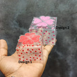 Two transparent heart-patterned gift boxes for bakery packaging, displayed on a hand.